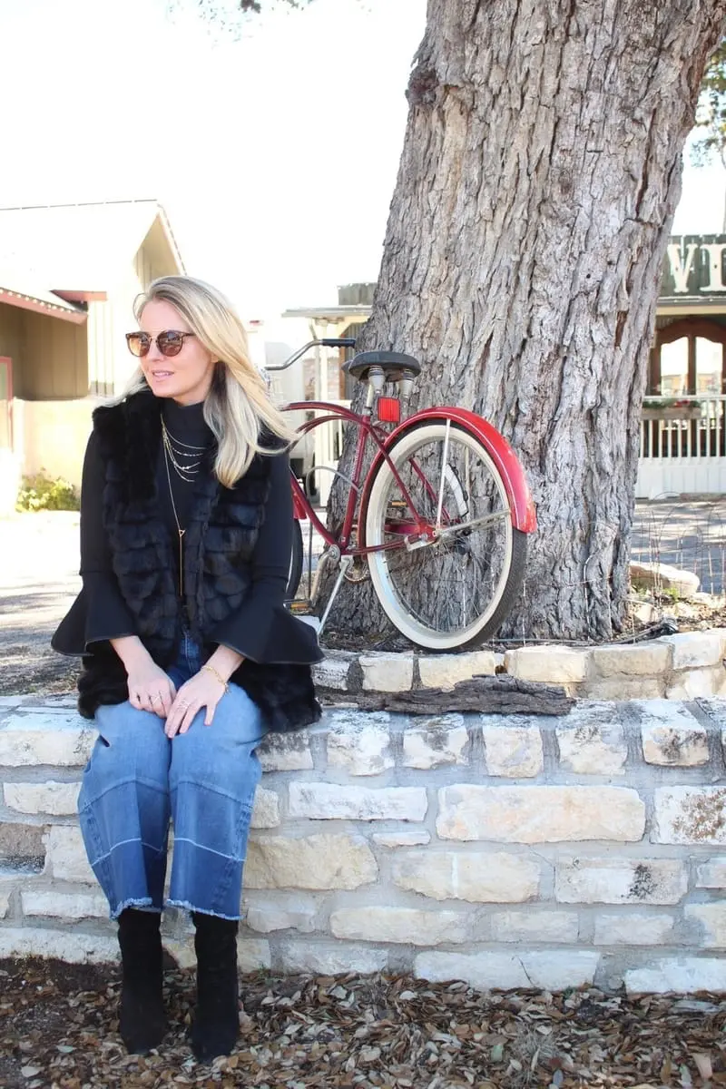 culotte jeans by olivia palmero from the nordstrom, chelsea 28 collaboration paired with tall black suede boots, a chicwish faux fur, hooded vest and a bell sleeve black top