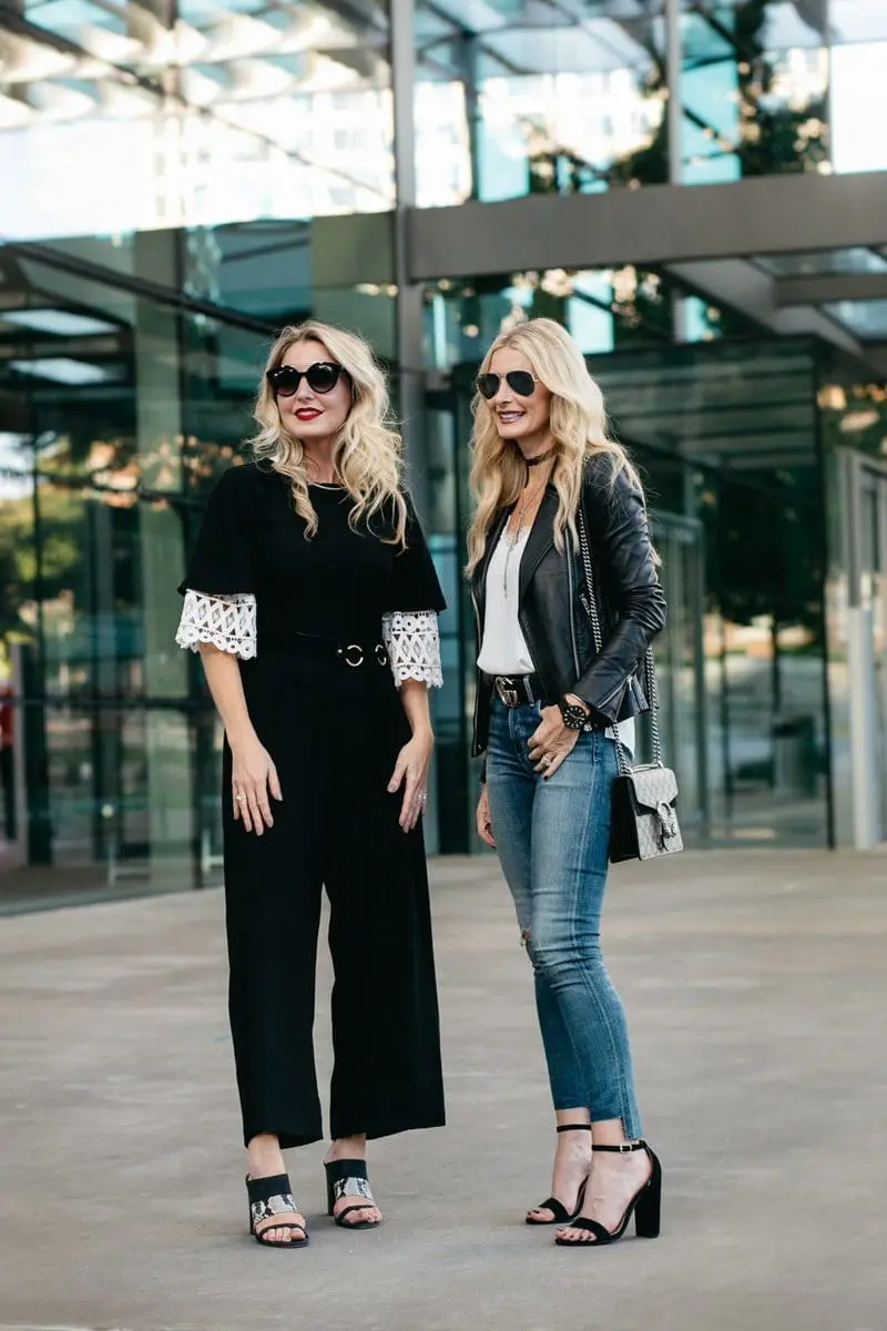 two fashion bloggers, erin busbee and heather anderson wearing black moto jackets in two different ways, one over a black Asos jumpsuit, the other over a tee and jeans.