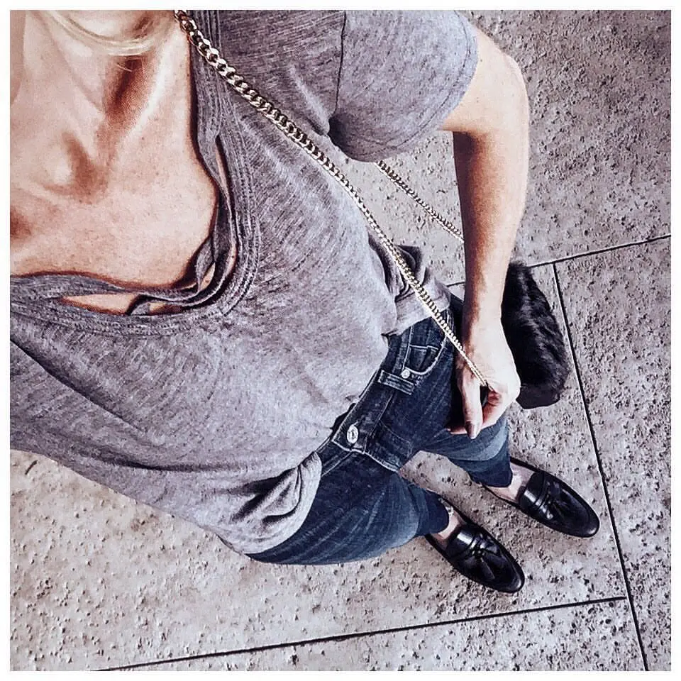 erin busbee wearing a gray criss cross front tee with dark wash skinny jeans and black flat mules by sam edelman