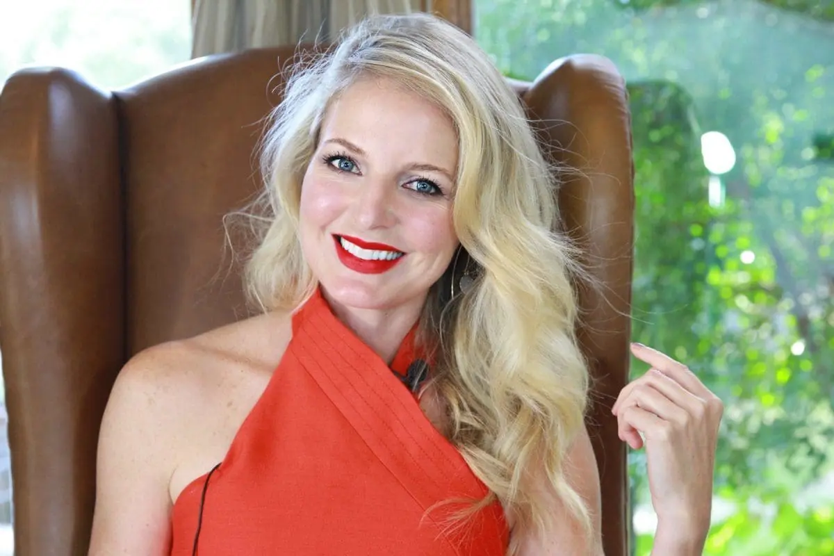 erin busbee with curled long blond hair with red halter top and red lipstick by sephora
