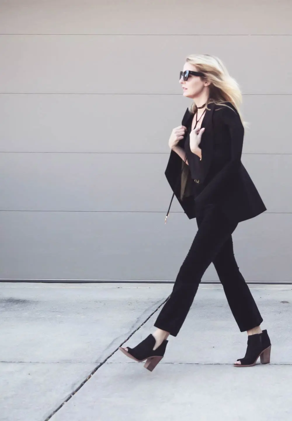 Erin Busbee, fashion blogger and wardrobe stylist from Busbee Style is wearing a Baublebar lariat choker necklace in black paired with a veronica beard scuba blazer and cropped, flared pants by Rag and Bone with Vince Camuto peep toe booties in black. Wear all one color to look longer and taller