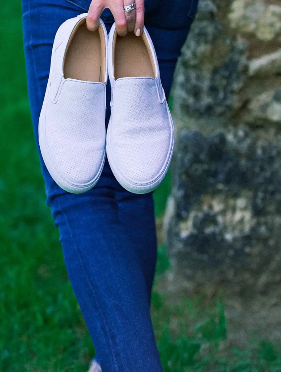 White sneakers slip on by Greats brand, worn 2 ways, including jeans and a one-shoulder top and a beige trench and white eyelet top, featured on Erin Busbee, of BusbeeStyle, fashion blogger and youtuber