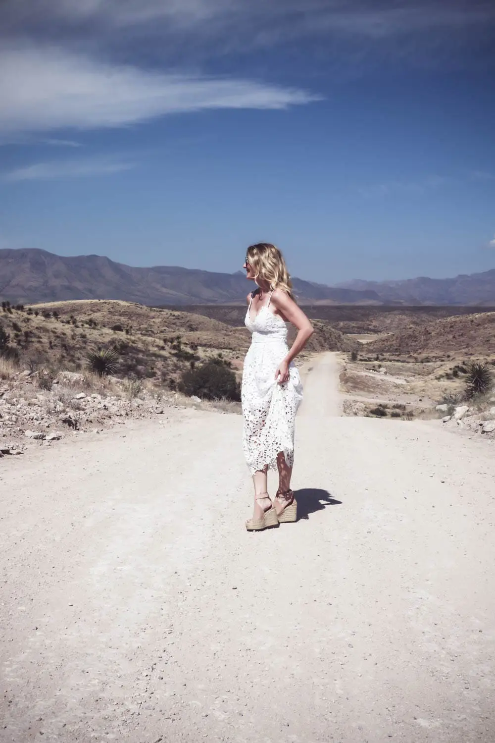Fashion blogger and fashion youtuber, erin busbee of busbeestyle.com, wearing a white lace dress by ASTR, nude leather espadrille sandals by Marc Fisher (super comfortable) and the mirrored aviator sunglasses are by Quay Australia in Marfa Texas 