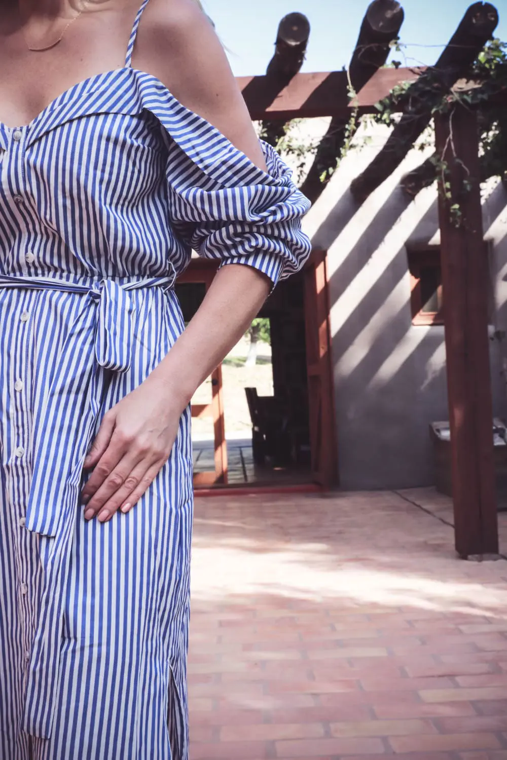 Fashion trends, cold shoulder, exposed shoulder, blue and white stripes, shirt dress by Bardot, sunglasses by Quay in silver aviator, and espadrille wedges in nude by Marc Fisher, at resort ranch in West Texas called Cibolo Creek 