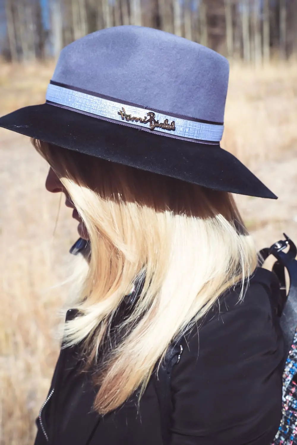 Styling Hats for women for fall and winter, featuring a Henri Bendel felt hat, paired with a jetsetter tweed backpack, veronica beard blazer with leather dickey and amo twist jeans with vince camuto patent booties on fashion blogger over 4o from Busbee Style Erin Busbee