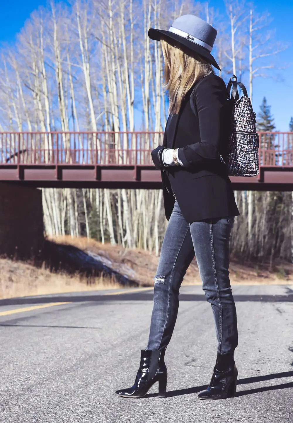 Styling Hats for women for fall and winter, featuring a Henri Bendel felt hat, paired with a jetsetter tweed backpack, veronica beard blazer with leather dickey and amo twist jeans with vince camuto patent booties on fashion blogger over 4o from Busbee Style Erin Busbee