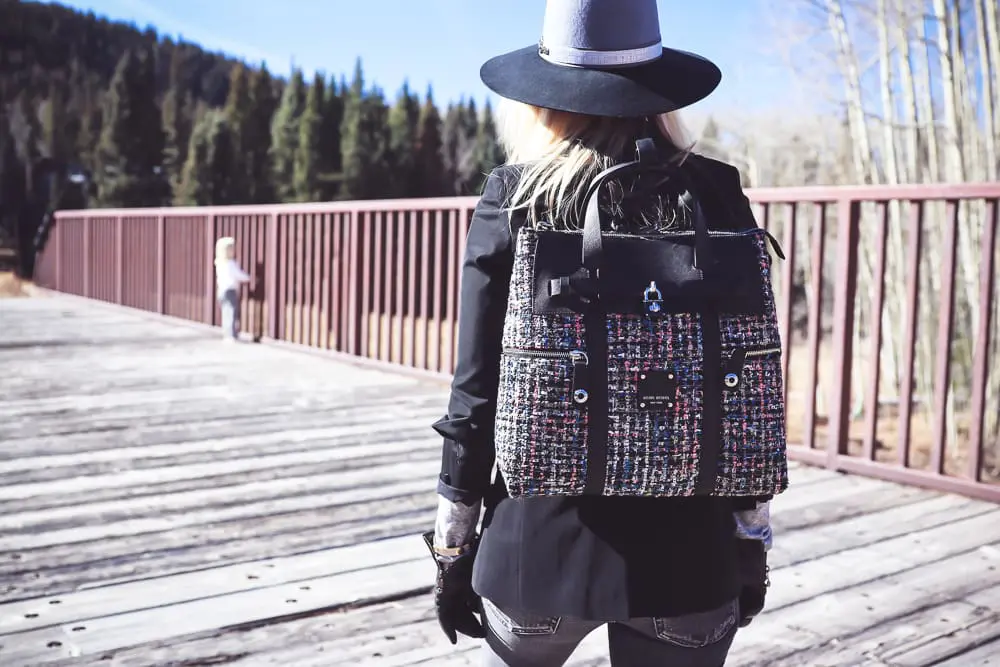 Styling Hats for women for fall and winter, featuring a Henri Bendel felt hat, paired with a jetsetter tweed backpack, veronica beard blazer with leather dickey and amo twist jeans with vince camuto patent booties on fashion blogger over 4o from Busbee Style Erin Busbee