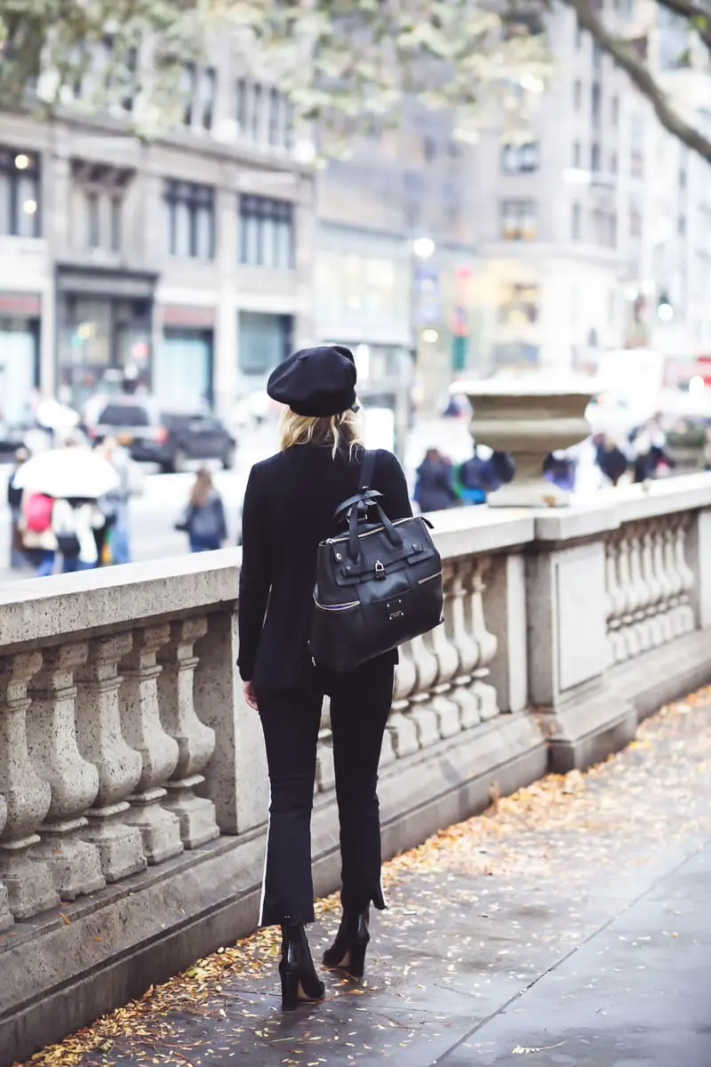 Beret, Fashion Blogger Erin Busbee of Busbee Style walking in New York City in an all black look with her cashmere beret, Mother racing stripe jeans, a choker cashmere black sweater by Aqua from Bloomingdales, her Jetsetter black leather backpack from Henri Bendel and black patent ankle boots by Vince Camuto