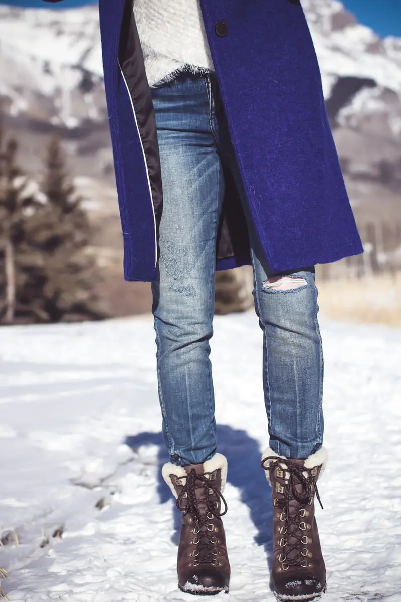 blue coat by Elie Tahari, boiled wool winter coat in beautiful color on fashion blogger over 40, Erin Busbee of Busbee Style wearing Henri Bendel sunglasses, Sorel conquest wedge booties, Amo twist skinny jeans and a Bloomingdales fuzzy white sweater in mountain village, colorado, snowy mountains