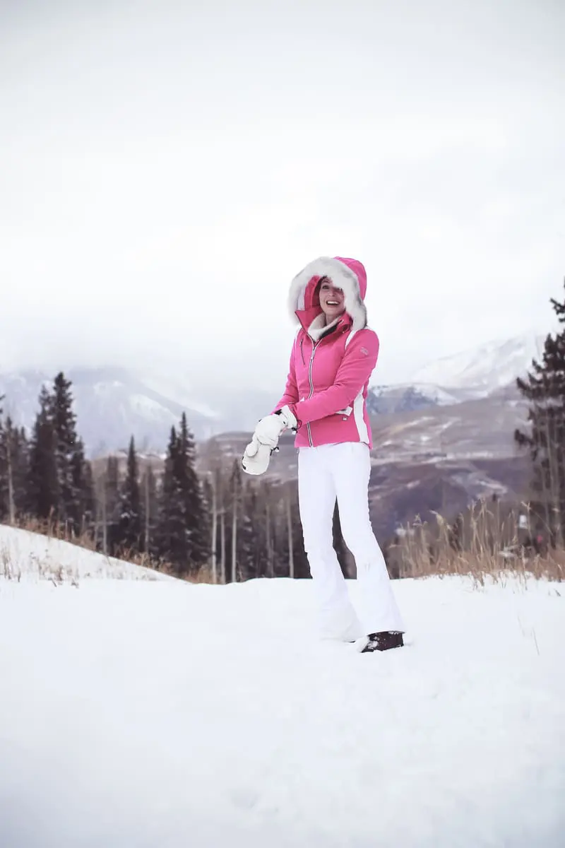 Fitness routine update, featuring lifestyle blogger over 40, Erin Busbee of Busbee Style, talking about skiing as great cardio wearing Nils US pink ski jacket, and Toni Sailer white ski pants