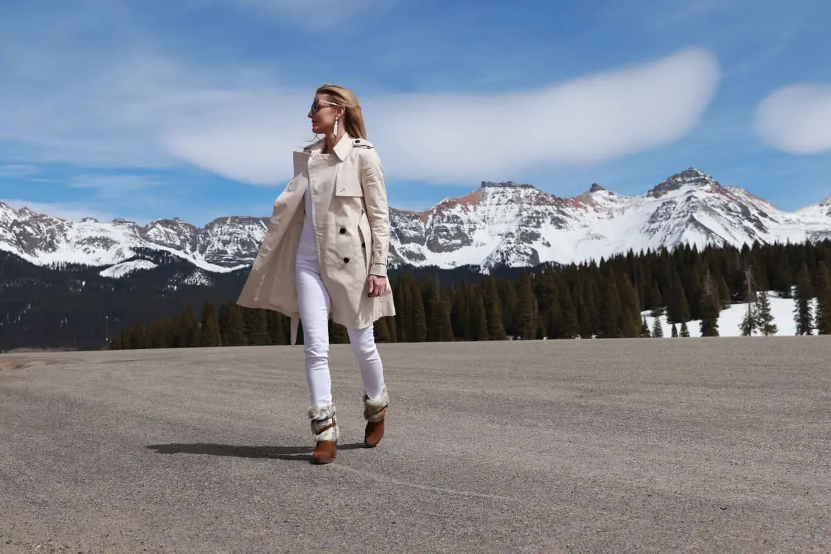 wearing Club Monaco champagne colored trench coat, white jeans, boots