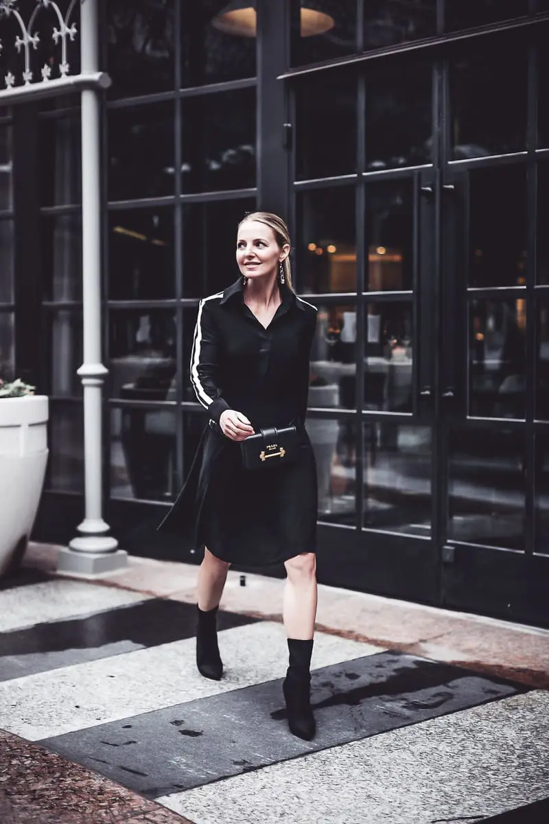 reward style conference 2018 featuring blond fashion blogger in black fit and flare dress with racing stripes by Norma Kamali, Stuart Weitzman hifi sock booties in black, prada belt bag