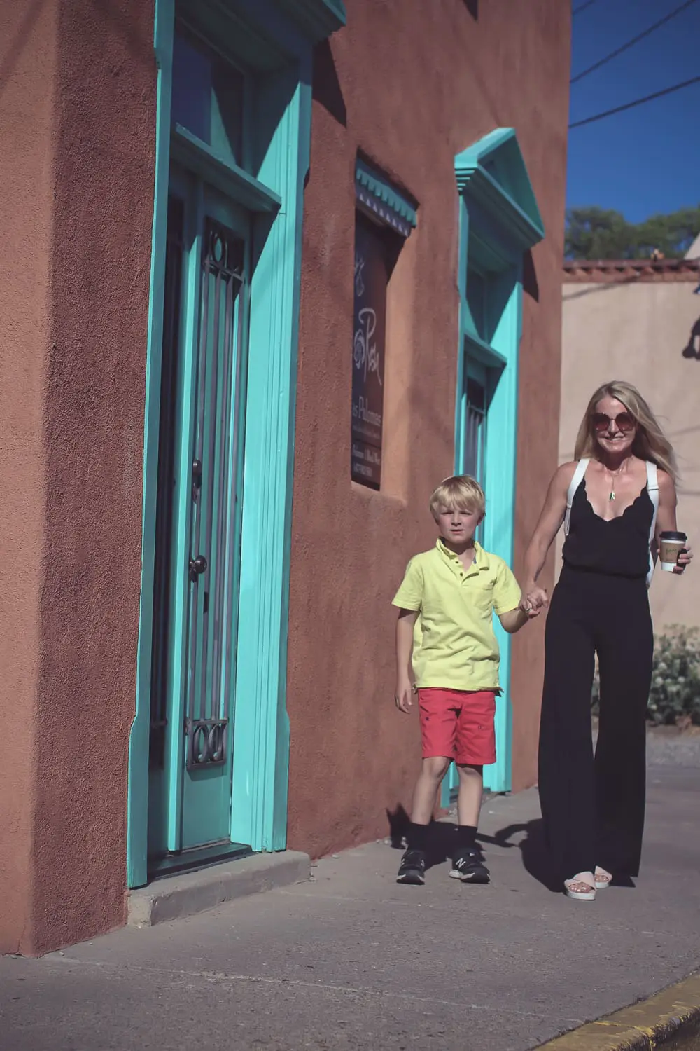 chic and sophisticated backpacks for grown ups by Henri Bendel, featuring blonde woman carrying a white Rivington convertible tote and backpack wearing all black with dainty gold and green jewelry