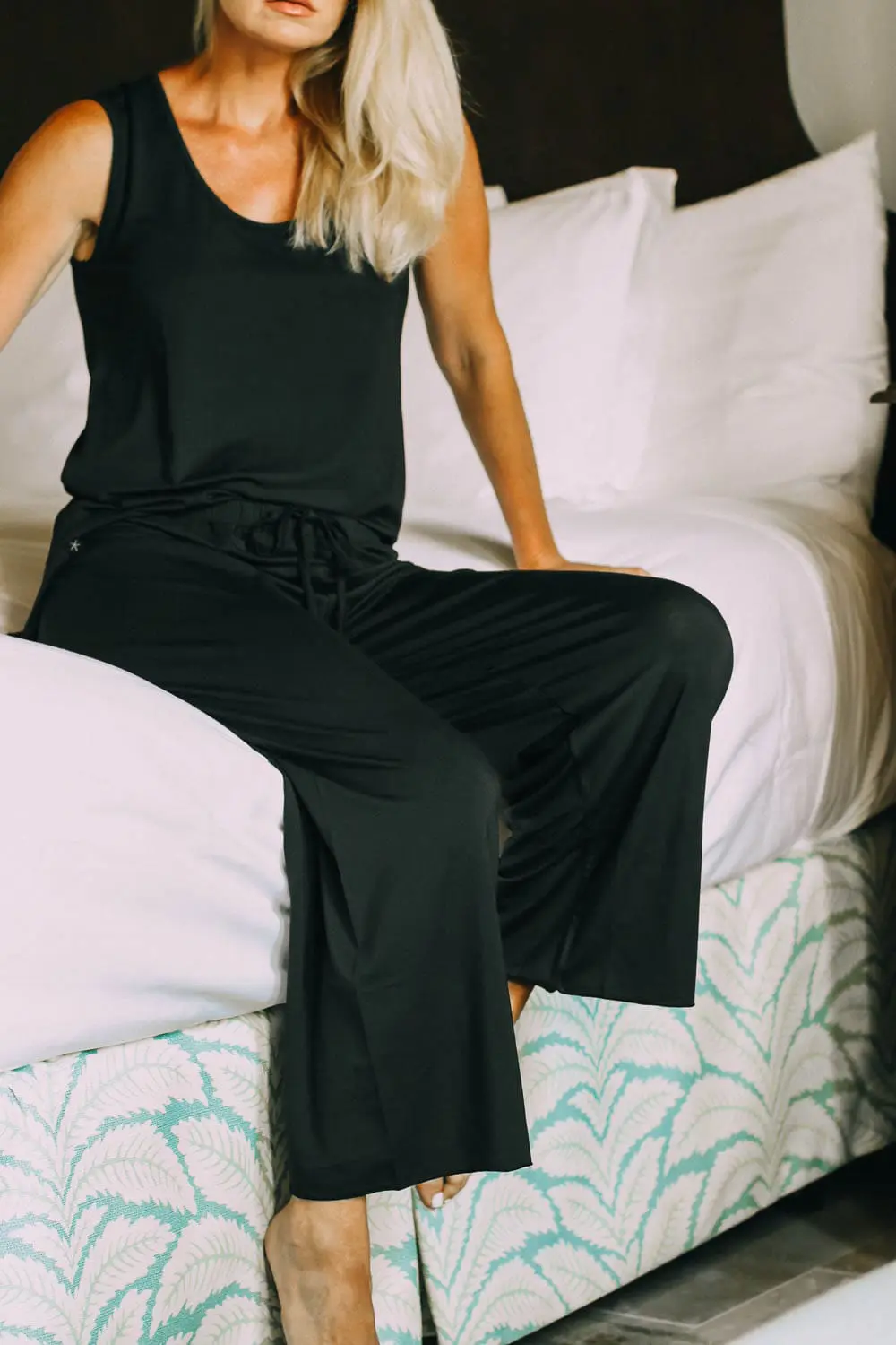 best pajamas, black luxe jersey sleeveless top and cropped pants pajamas set by Barefoot Dreams on blonde woman