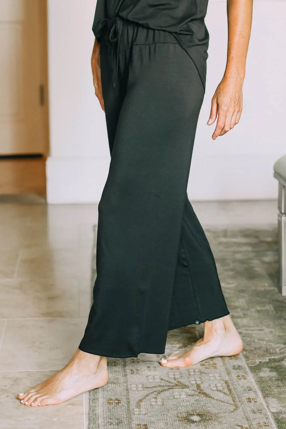 best pajamas, black luxe jersey sleeveless top and cropped pants pajamas set by Barefoot Dreams on blonde woman