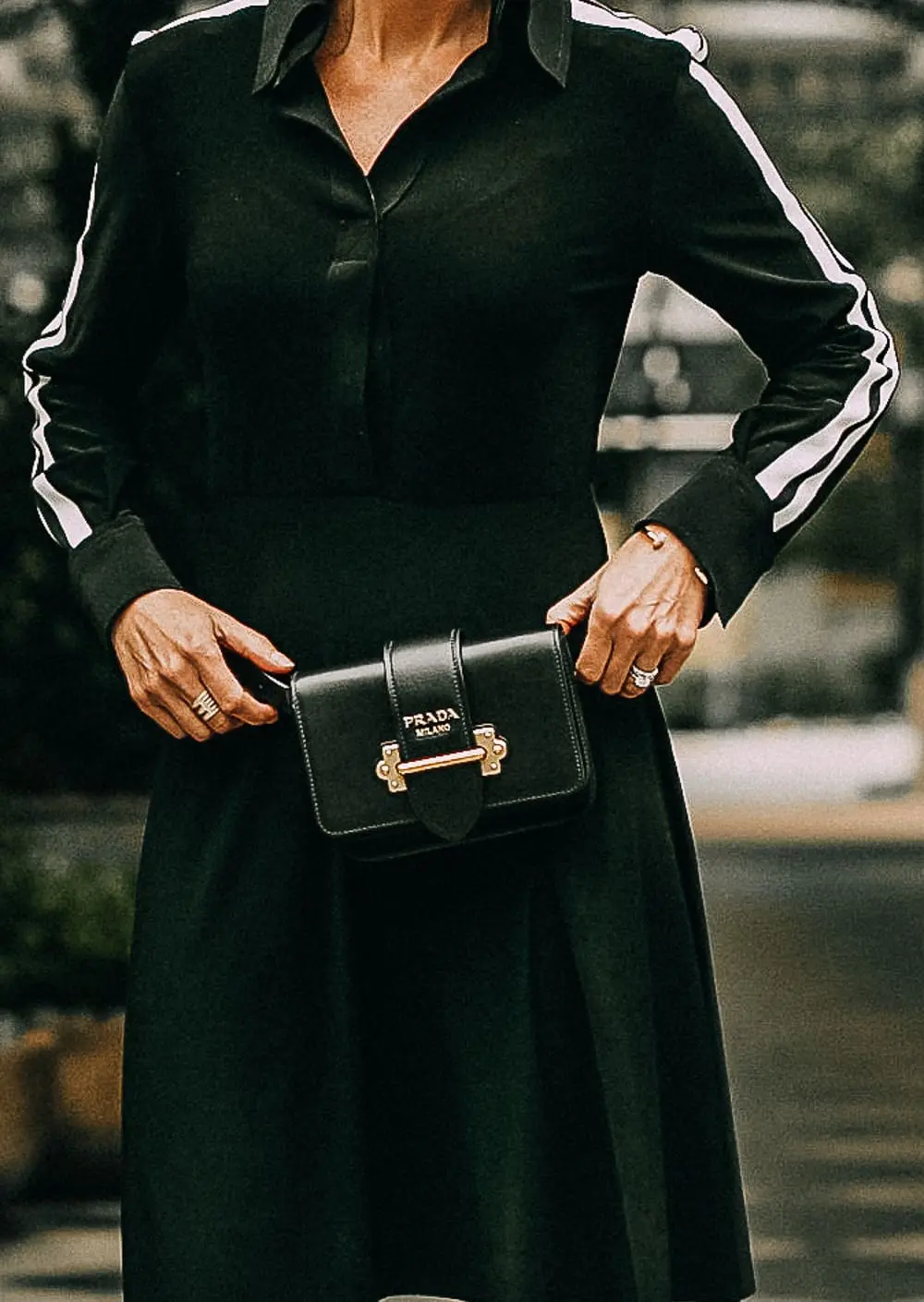 Belt Bags, styling a Prada cahier belt bag and crossbody bag with a black dress by Norma Kamali paired with sock booties by Stuart Weitzman on blonde woman, fashion blogger Erin Busbee of Busbeestyle.com
