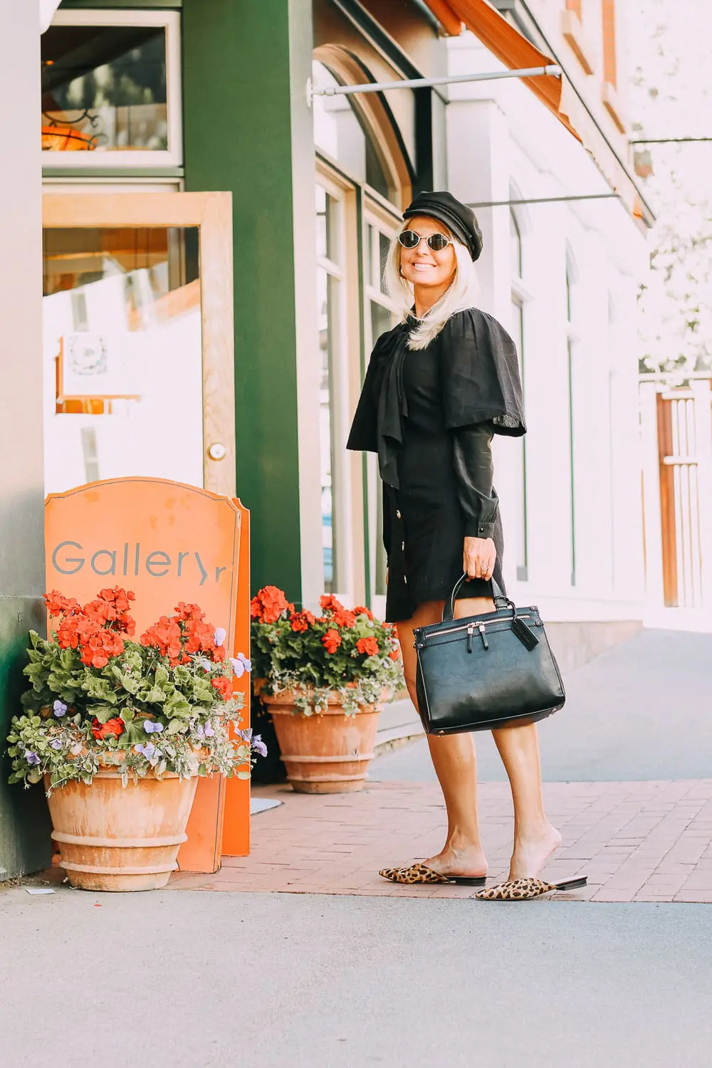 Vegan Leather Handbag by Sole Society paired with black Topshop dress, bow blouse, and newsboy cap on fashion blogger Erin Busbee of BusbeeStyle.com in Telluride, Colorado with small Quay sunglasses