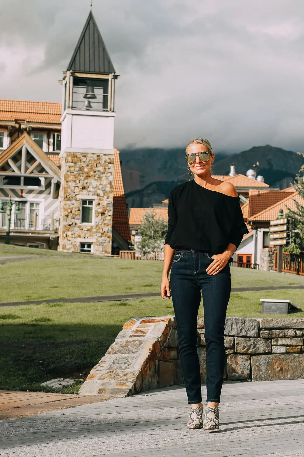 Best Jeans for Curves by Not Your Daughter's Jeans or NYDJ paired with black of shoulder dolman top, Quay aviator sunglasses, gold earrings on fashion blogger over 40, Erin Busbee of busbee style