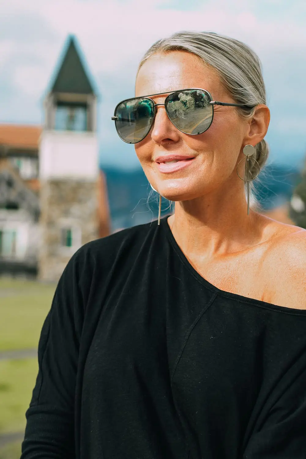Best Jeans for Curves by Not Your Daughter's Jeans or NYDJ paired with black of shoulder dolman top, Quay aviator sunglasses, gold earrings on fashion blogger over 40, Erin Busbee of busbee style