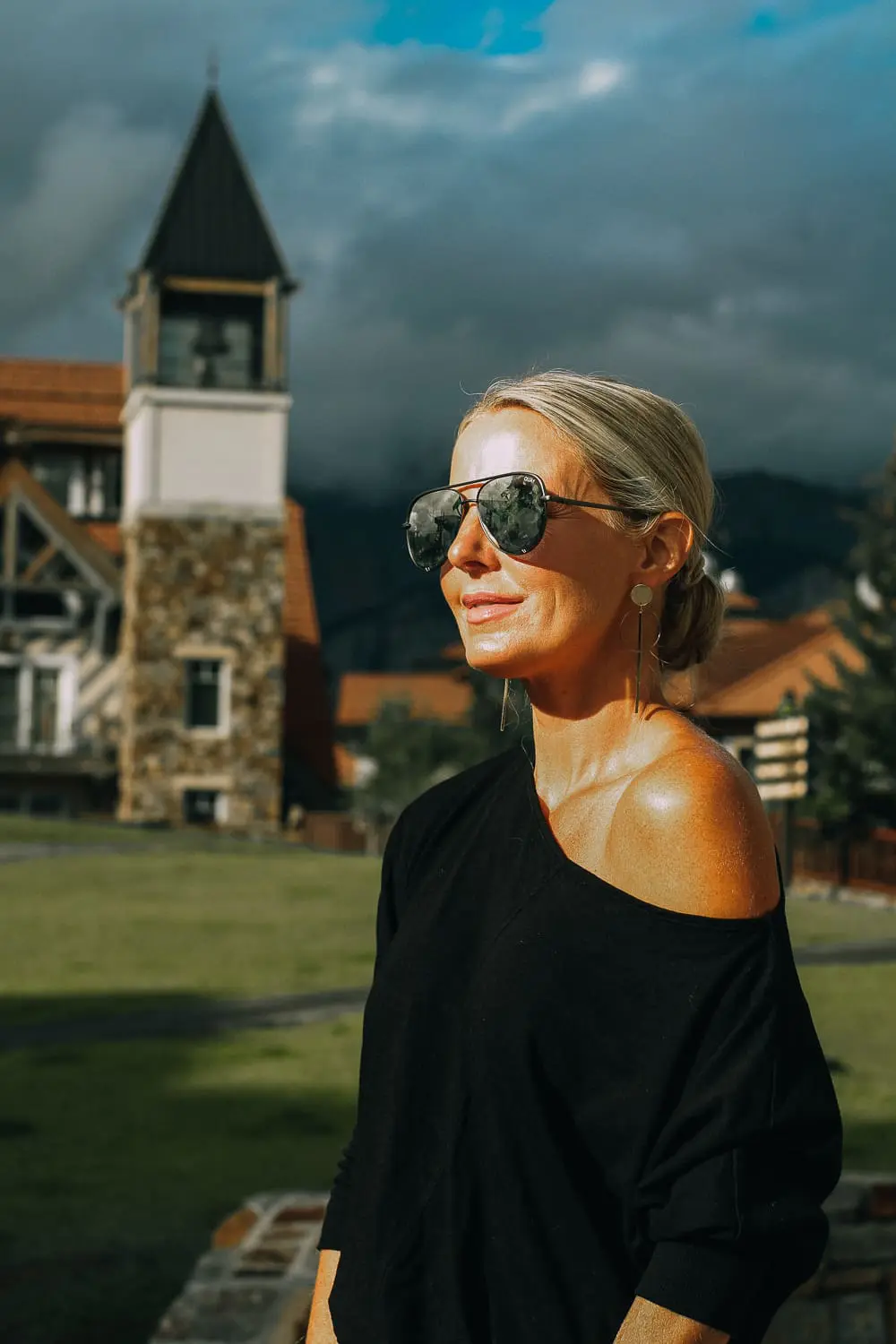 Best Jeans for Curves by Not Your Daughter's Jeans or NYDJ paired with black of shoulder dolman top, Quay aviator sunglasses, gold earrings on fashion blogger over 40, Erin Busbee of busbee style