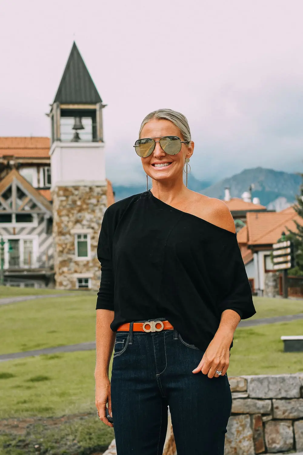Best Jeans for Curves by Not Your Daughter's Jeans or NYDJ paired with black of shoulder dolman top, Quay aviator sunglasses, gold earrings on fashion blogger over 40, Erin Busbee of busbee style