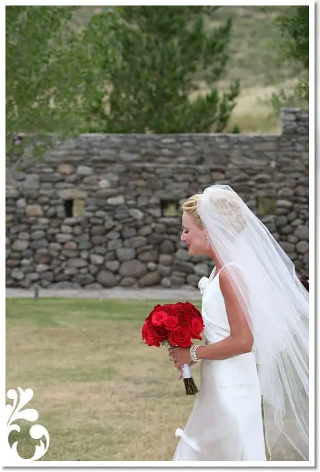 Fashion Blogger Erin Busbee Walking Down the Aisle in Wedding Dress Carrying Red Rose Bouquet