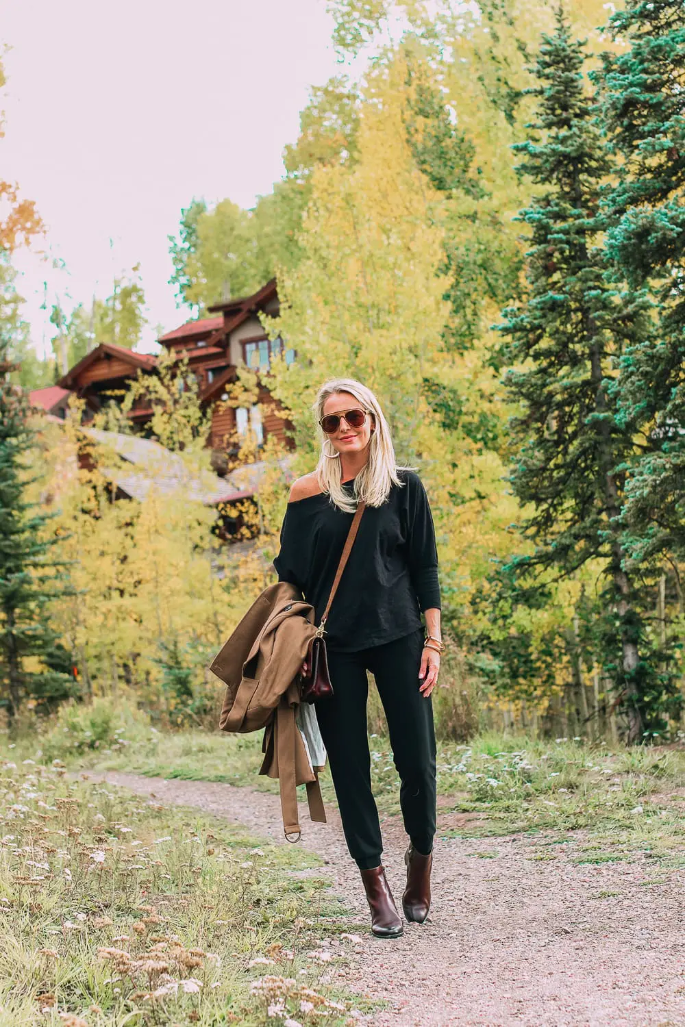 ankle boots for walking in Bison brown with low block heel and comfort, cushion technology by ECCO on fashion blogger in black joggers by Norma Kamali and black off shoulder top with brown crossbody bag
