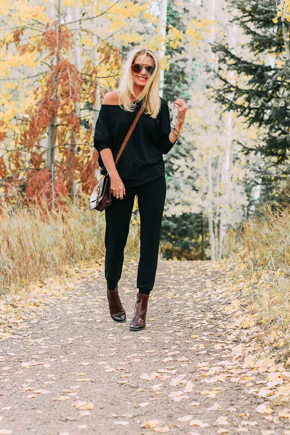 ankle boots for walking in Bison brown with low block heel and comfort, cushion technology by ECCO on fashion blogger in black joggers by Norma Kamali and black off shoulder top with brown crossbody bag