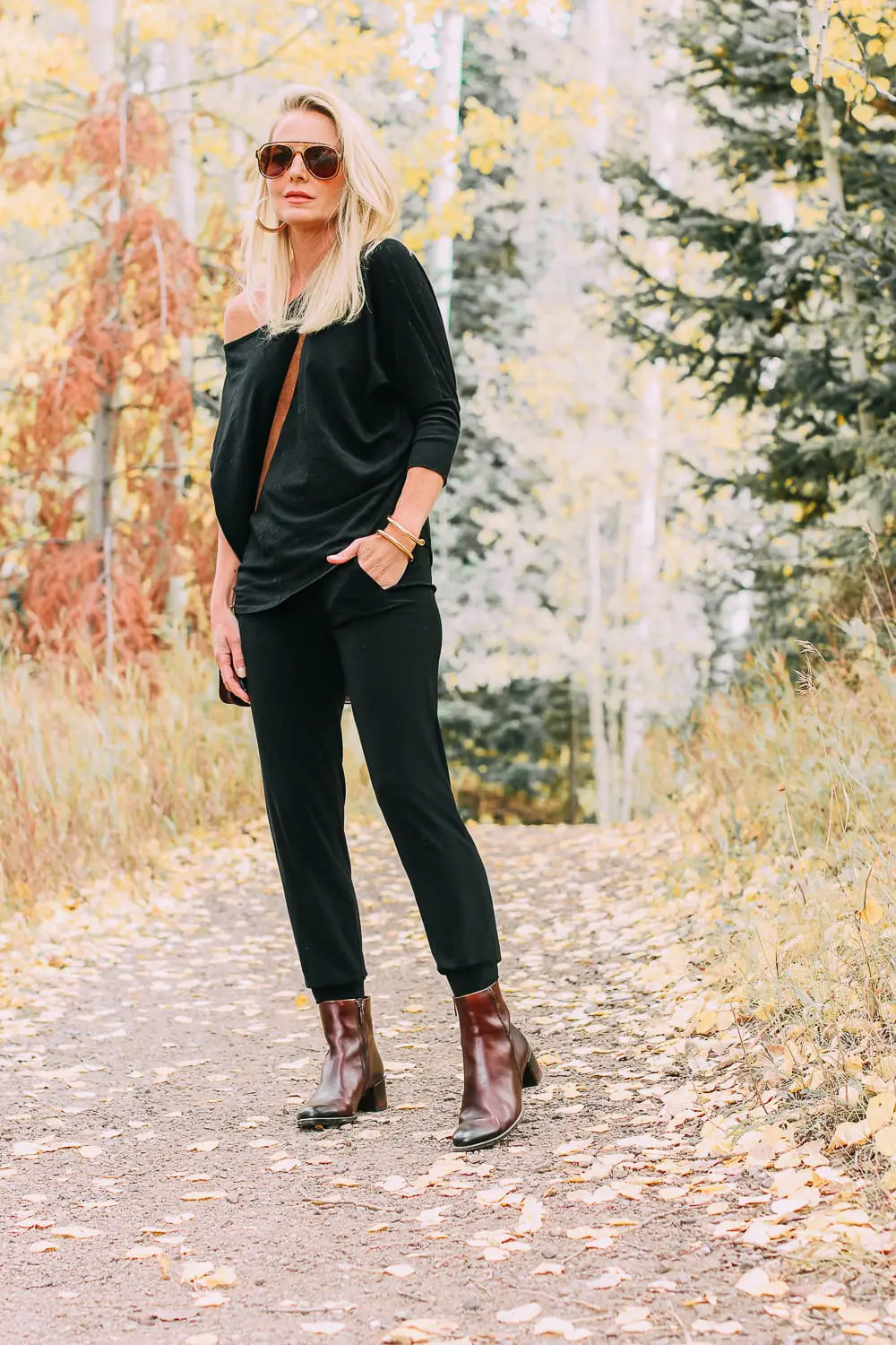 ankle boots for walking in Bison brown with low block heel and comfort, cushion technology by ECCO on fashion blogger in black joggers by Norma Kamali and black off shoulder top with brown crossbody bag