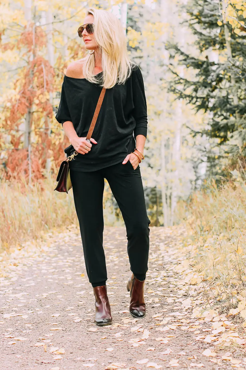 ankle boots for walking in Bison brown with low block heel and comfort, cushion technology by ECCO on fashion blogger in black joggers by Norma Kamali and black off shoulder top with brown crossbody bag