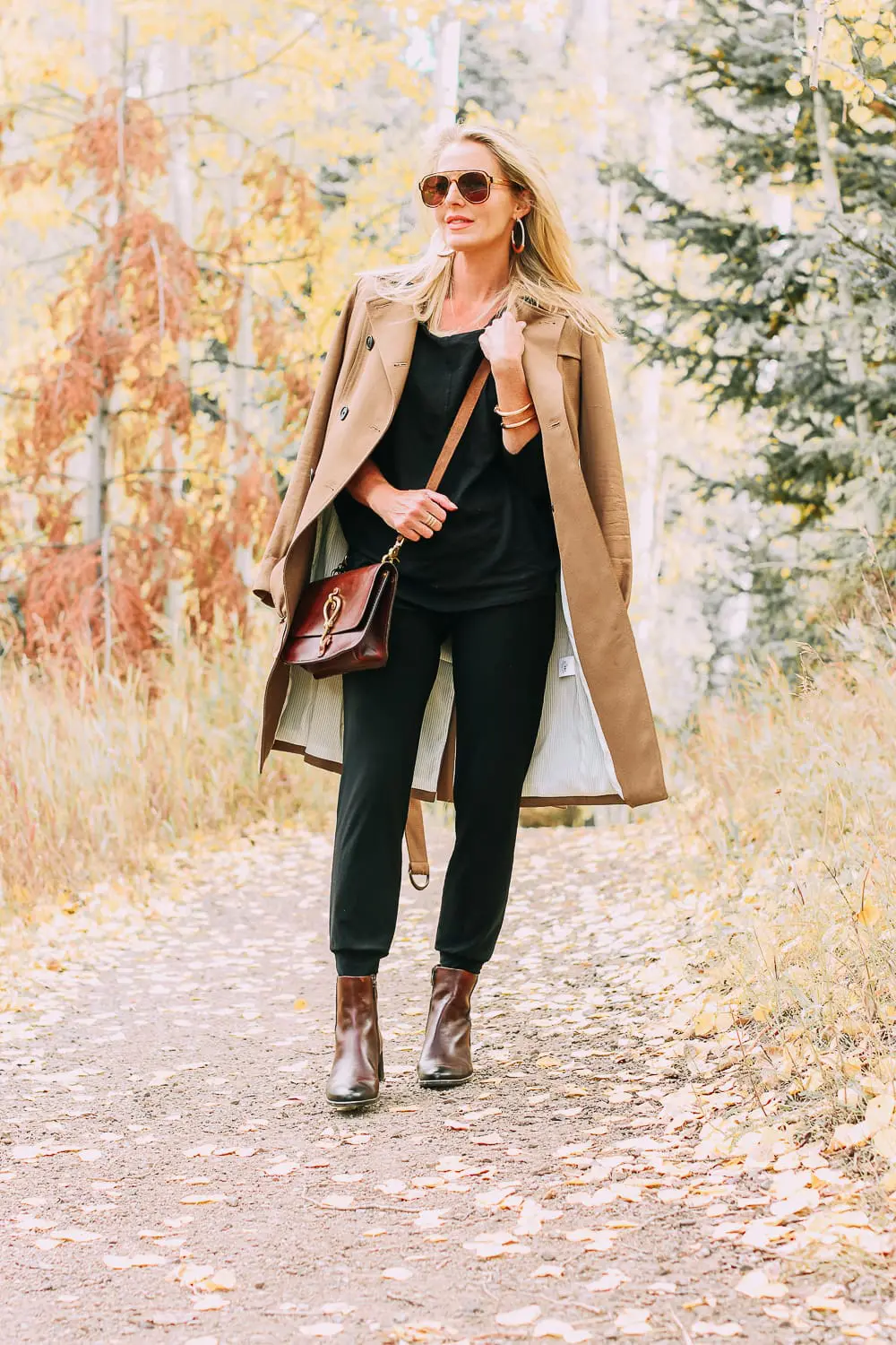 ankle boots for walking in Bison brown with low block heel and comfort, cushion technology by ECCO on fashion blogger in black joggers by Norma Kamali and black off shoulder top with brown crossbody bag
