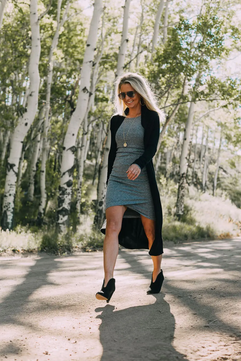 fall booties 2018 featuring black dressy booties by Vince Camuto in black suede paired with a ruched gray t-shirt dress with long sleeves and a long black cardigan sweater on fashion blogger over 40, Erin Busbee of Busbee Style