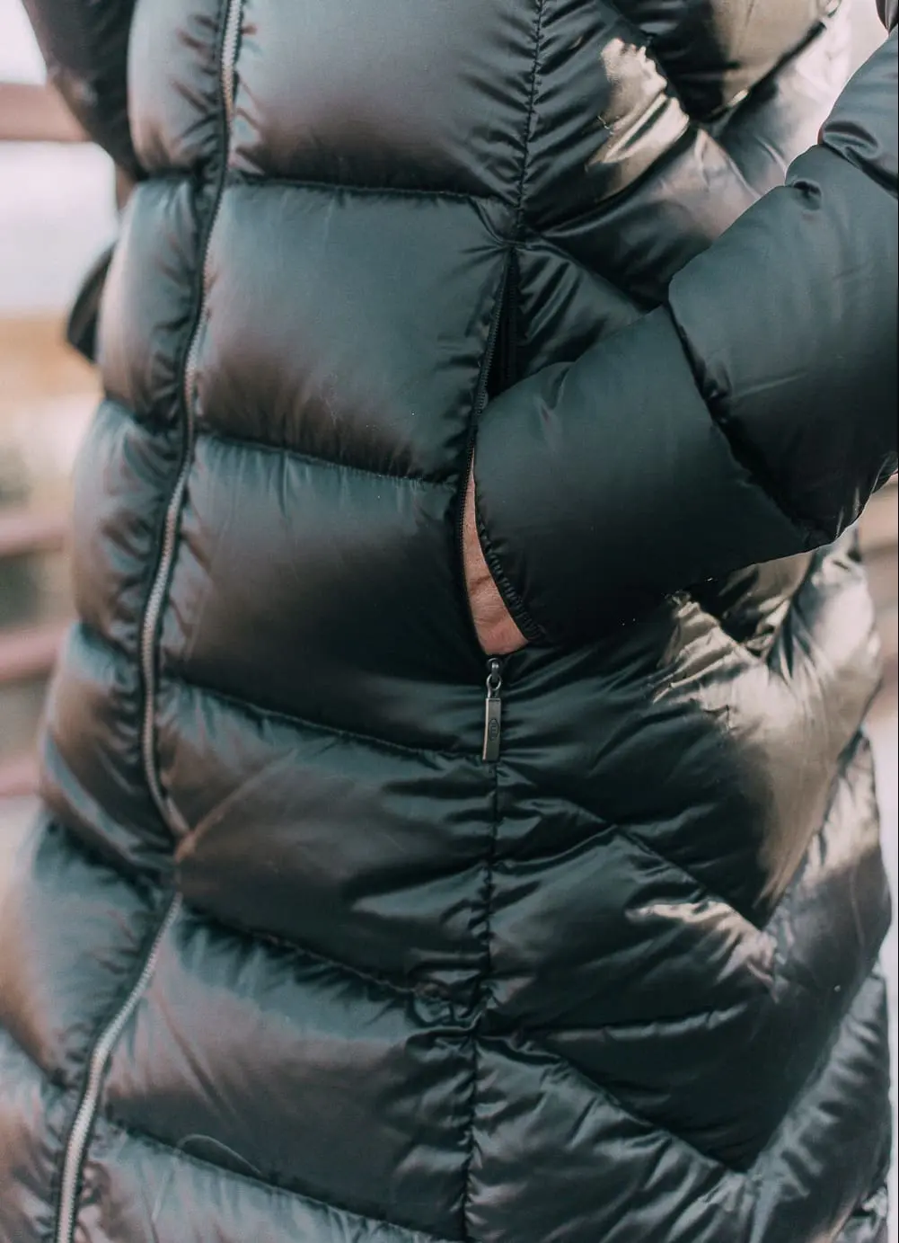 best puffer coats for women by Parajumpers from Bloomingdales in black, long puffer coat paired with dark jeans, black Ugg wedge booties on blonde woman