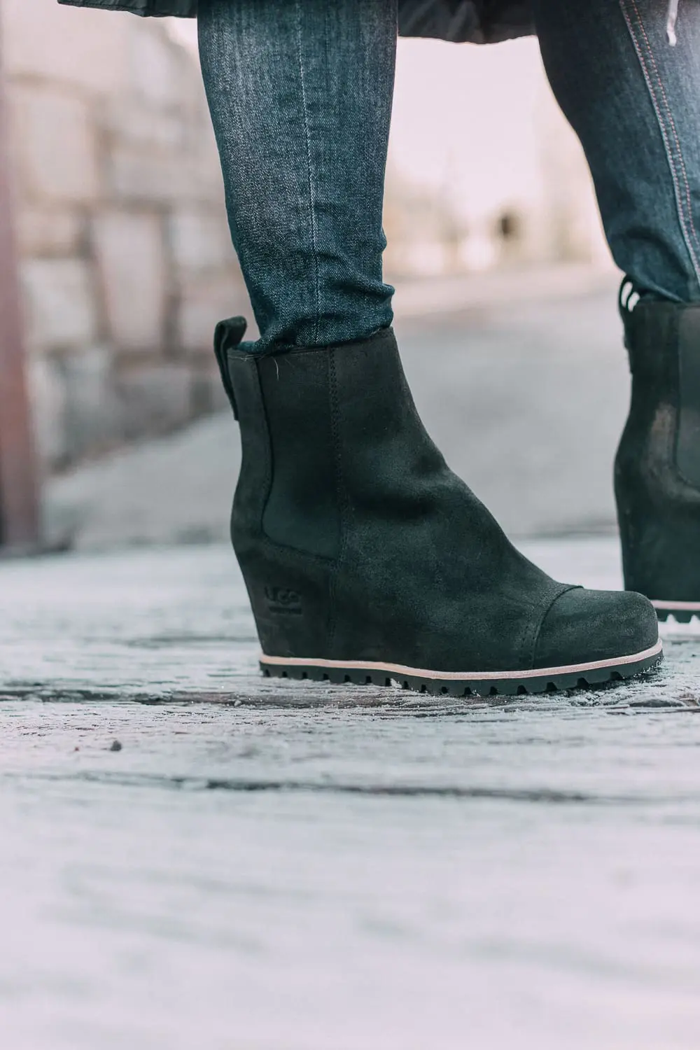 best puffer coats for women by Parajumpers from Bloomingdales in black, long puffer coat paired with dark jeans, black Ugg wedge booties on blonde woman
