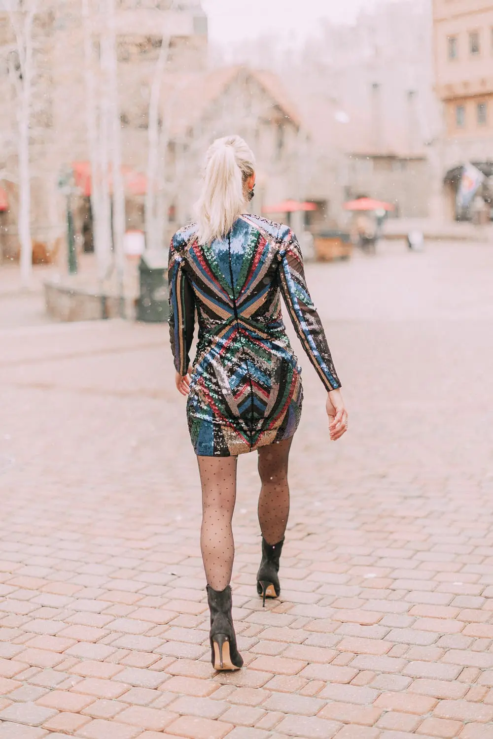 Unexpected holiday party outfits featuring a long-sleeve, colorful sequin mini dress from Express on blonde fashion blogger in the snow in Telluride, Colorado