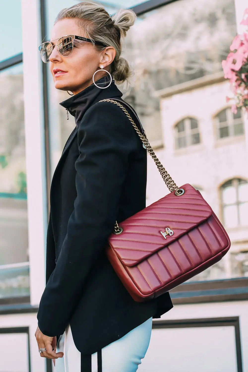 Henri Bendel quilted crossbody bag in burgundy with gold chain link detail paired with Pam & Gela striped pants, Bogner turtleneck and black blazer