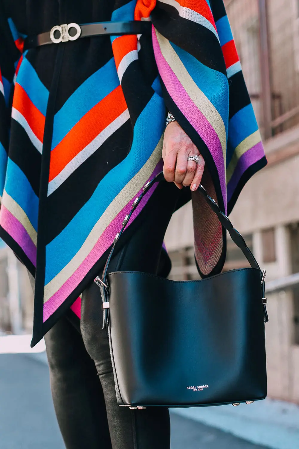 striped poncho, spanx leggings, vince camuto booties and henri bendel black bucket bag with gold hardware