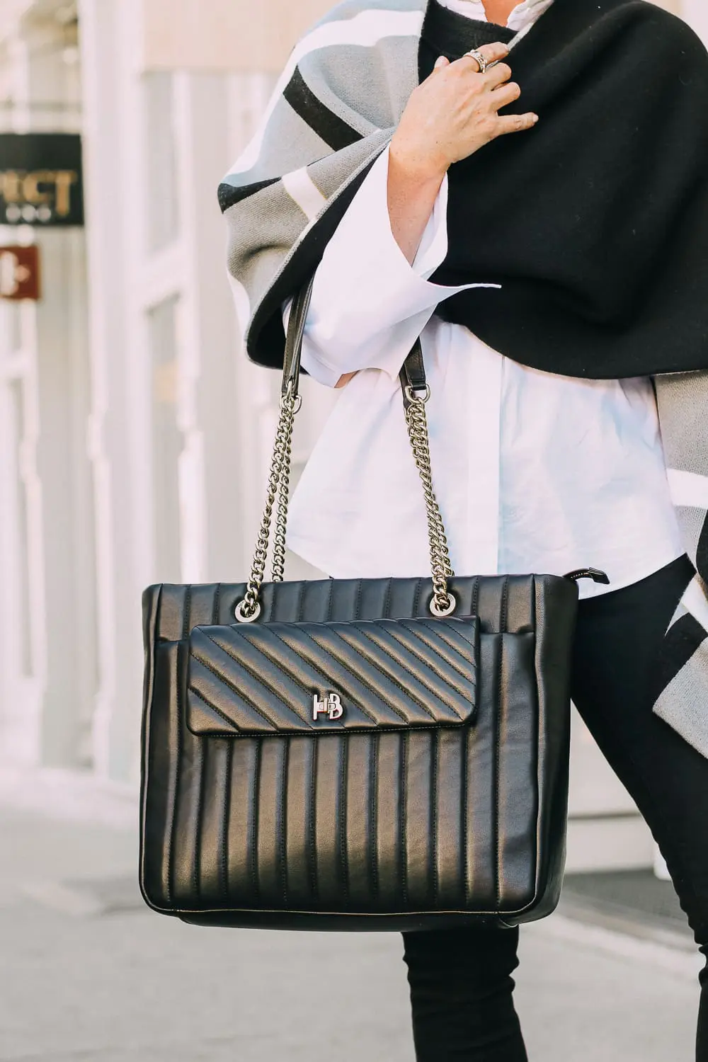 best work tote, quilted in black with chain link handles by Henri Bendel, paired with black jeans, patent leather sock booties, white Lafayette button down shirt and wrap