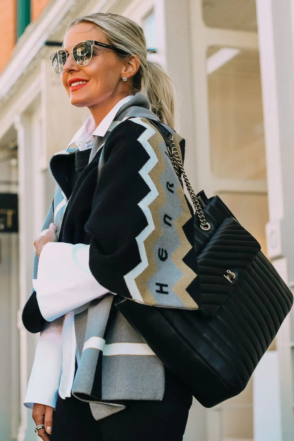 best work tote, quilted in black with chain link handles by Henri Bendel, paired with black jeans, patent leather sock booties, white Lafayette button down shirt and wrap