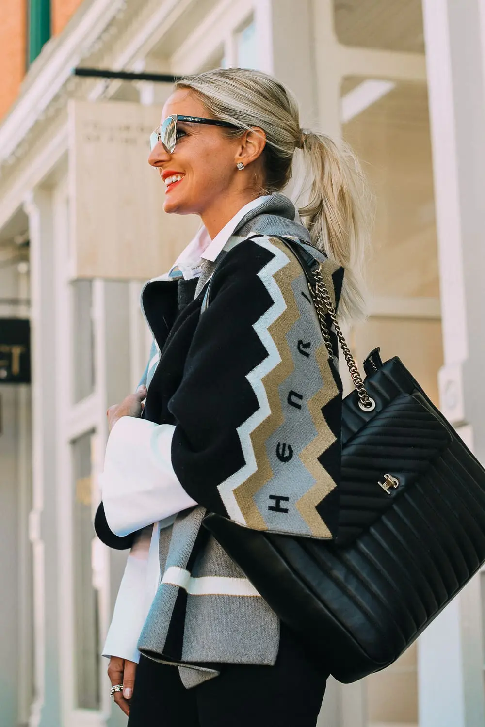 best work tote, quilted in black with chain link handles by Henri Bendel, paired with black jeans, patent leather sock booties, white Lafayette button down shirt and wrap