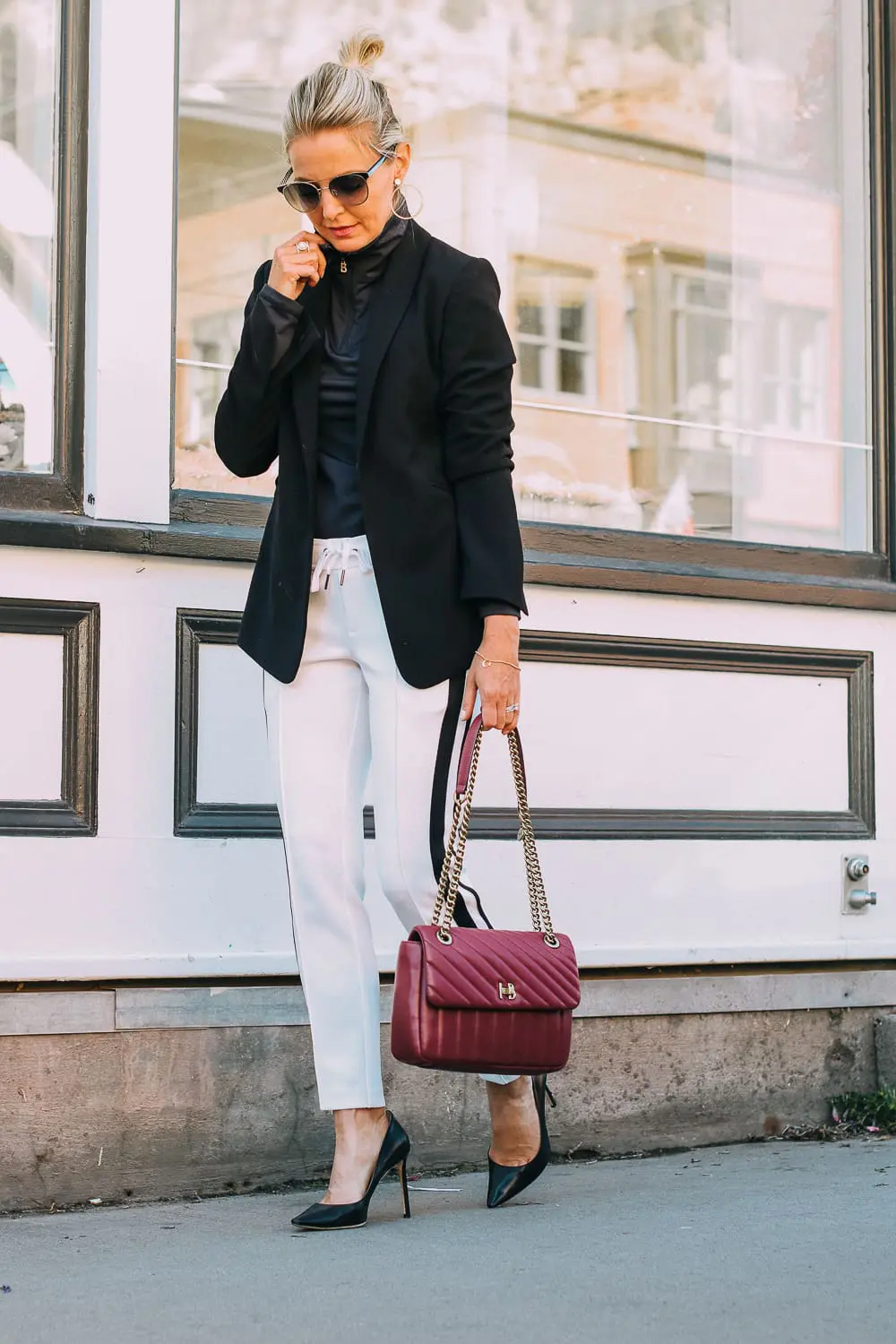 Henri Bendel quilted crossbody bag in burgundy with gold chain link detail paired with Pam & Gela striped pants, Bogner turtleneck and black blazer