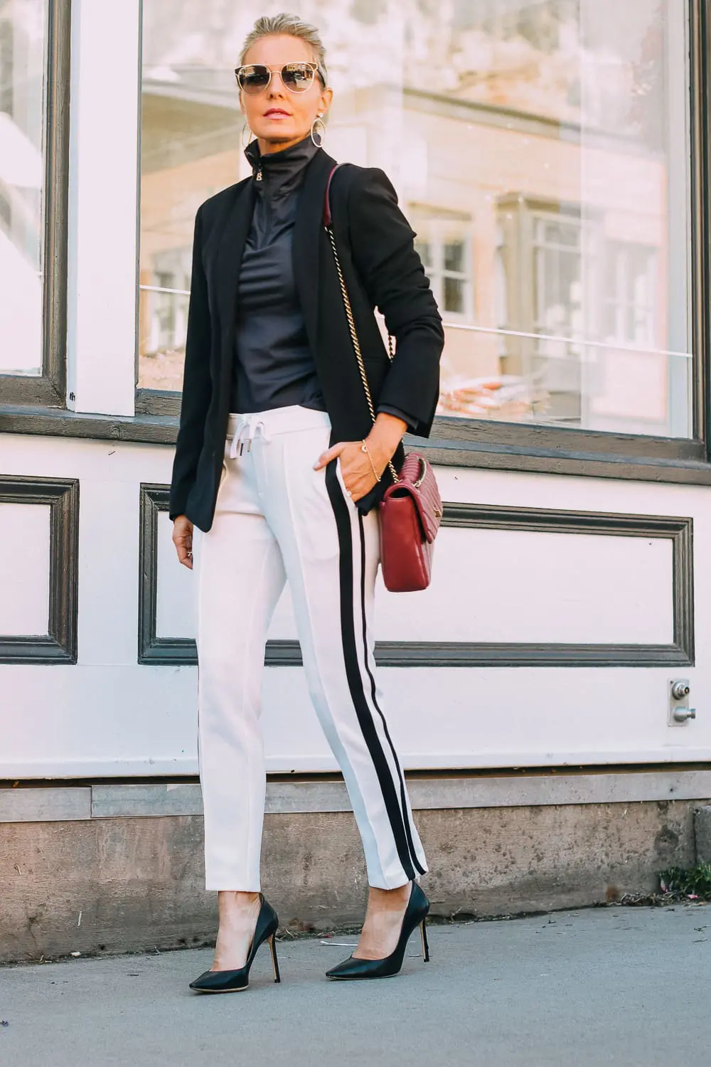 Henri Bendel quilted crossbody bag in burgundy with gold chain link detail paired with Pam & Gela striped pants, Bogner turtleneck and black blazer
