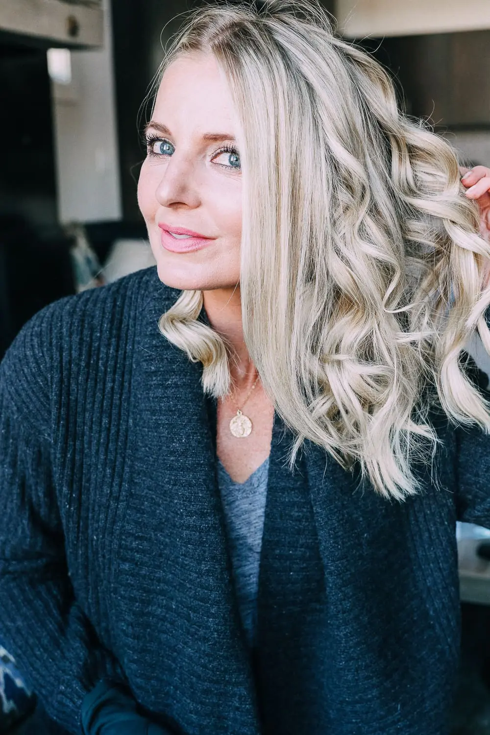 Curling your hair with a wand, step by step instructions by beauty blogger Erin Busbee with long blonde hair