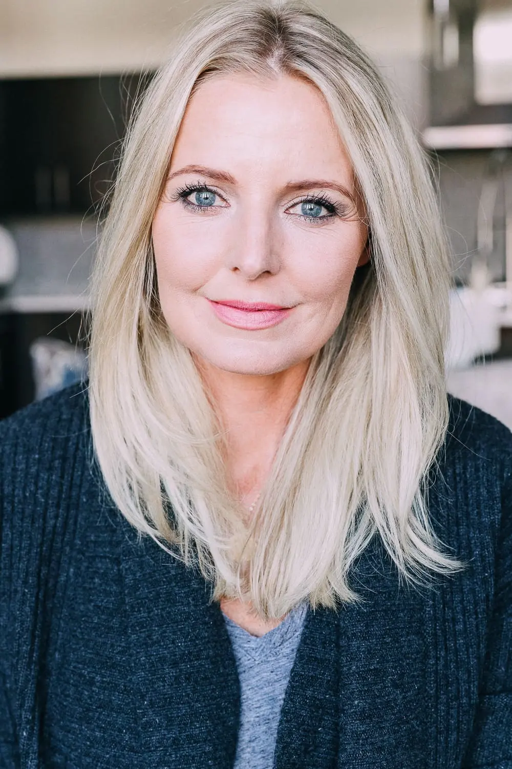 Curling your hair with a wand, step by step instructions by beauty blogger Erin Busbee with long blonde hair