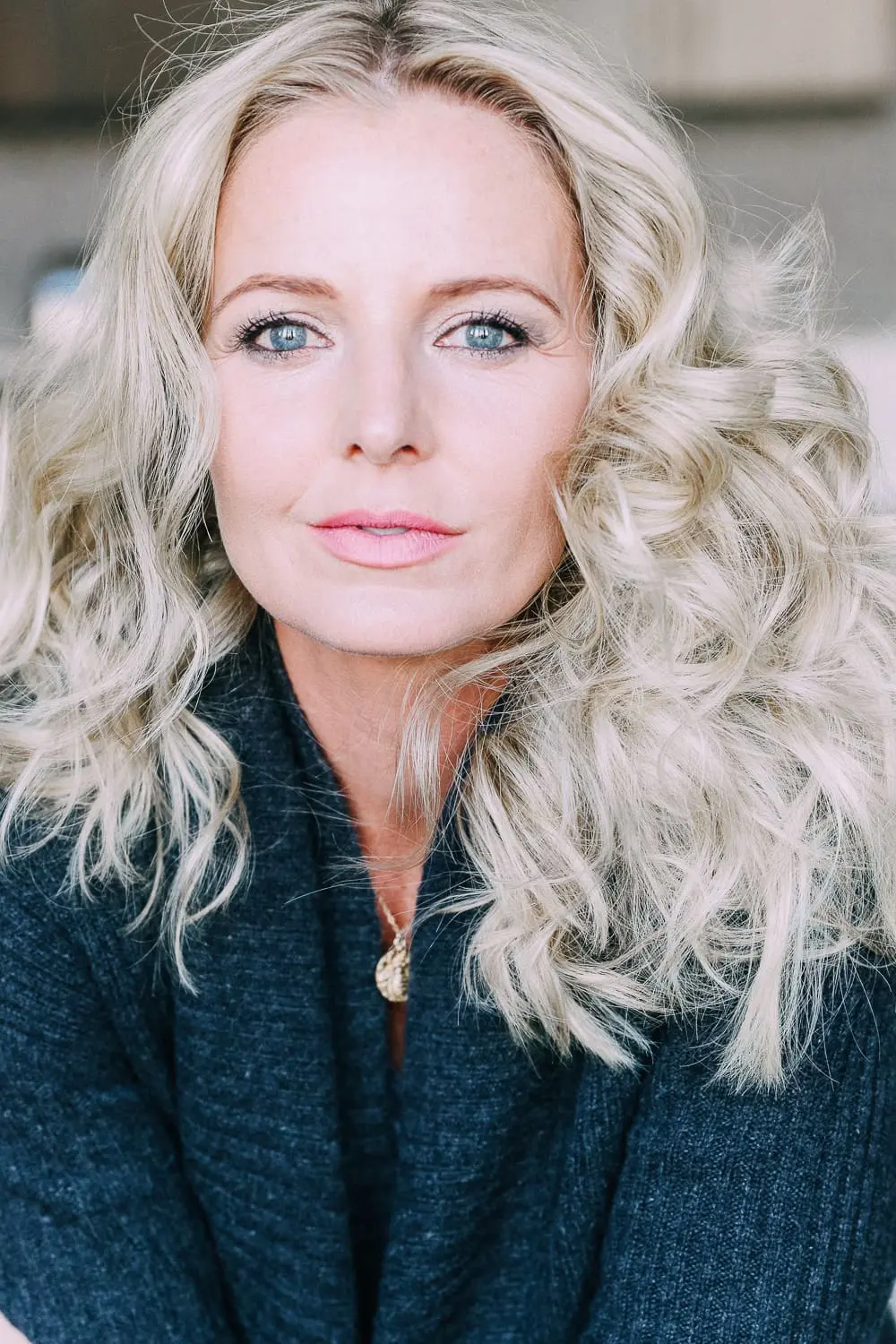 Curling your hair with a wand, step by step instructions by beauty blogger Erin Busbee with long blonde hair