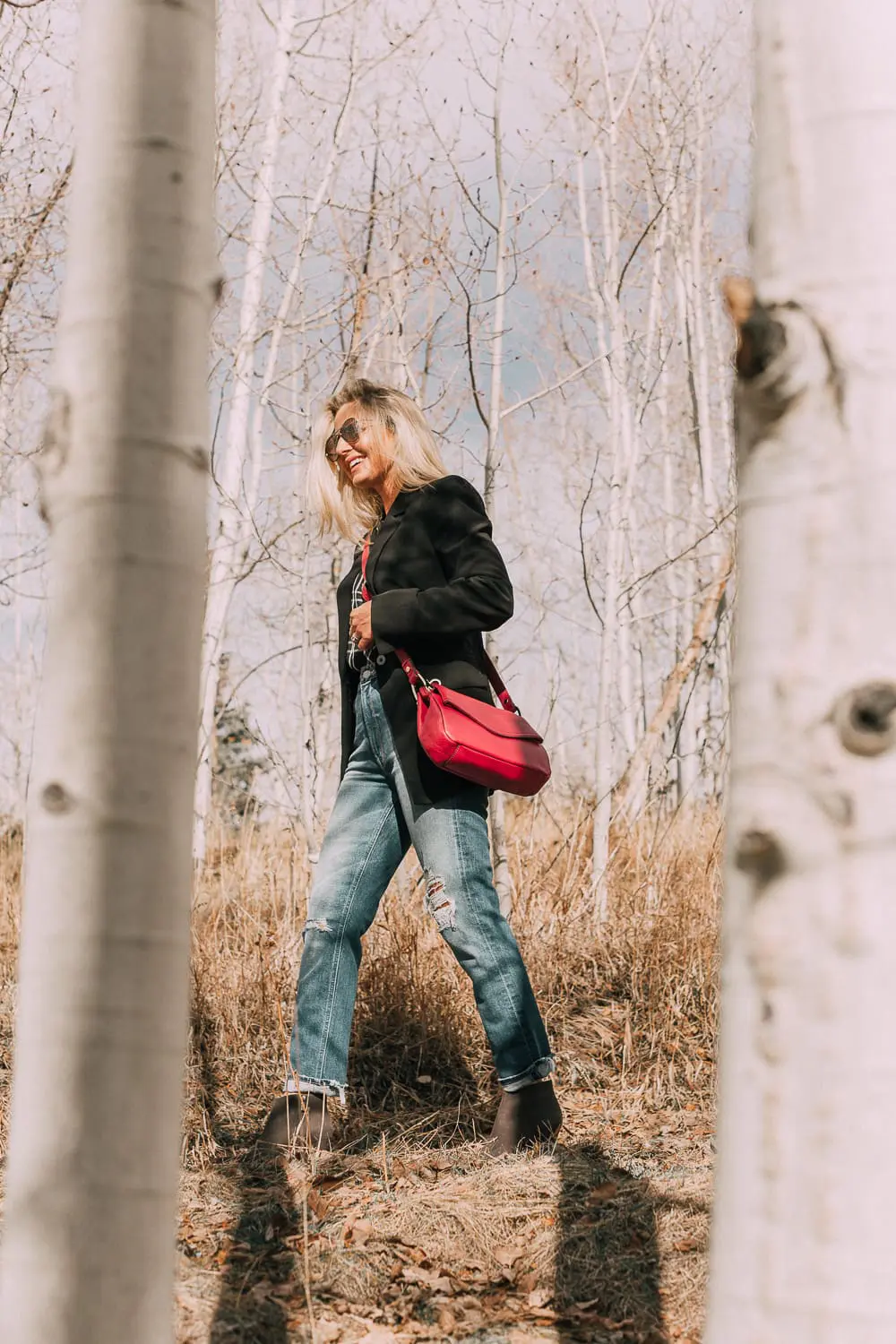Bootie Trend, styling gray suede short ankle boots by Vince Camuto with Mother cropped jeans, rails black and white plaid shirt, black donna karen blazer and a red crossbody bag on fashion blogger Erin Busbee