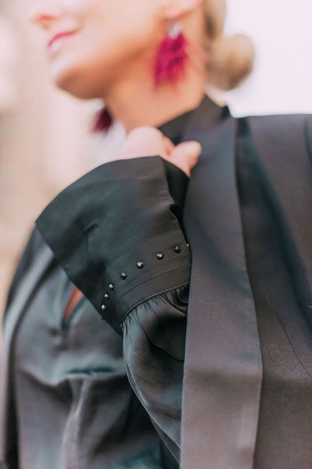What to wear to a holiday party when it's cold outside, featuring a burgundy pencil skirt, black silky tie neck blouse, black diamond print tights, crystal studded ankle booties, and a black tuxedo blazer from Express 