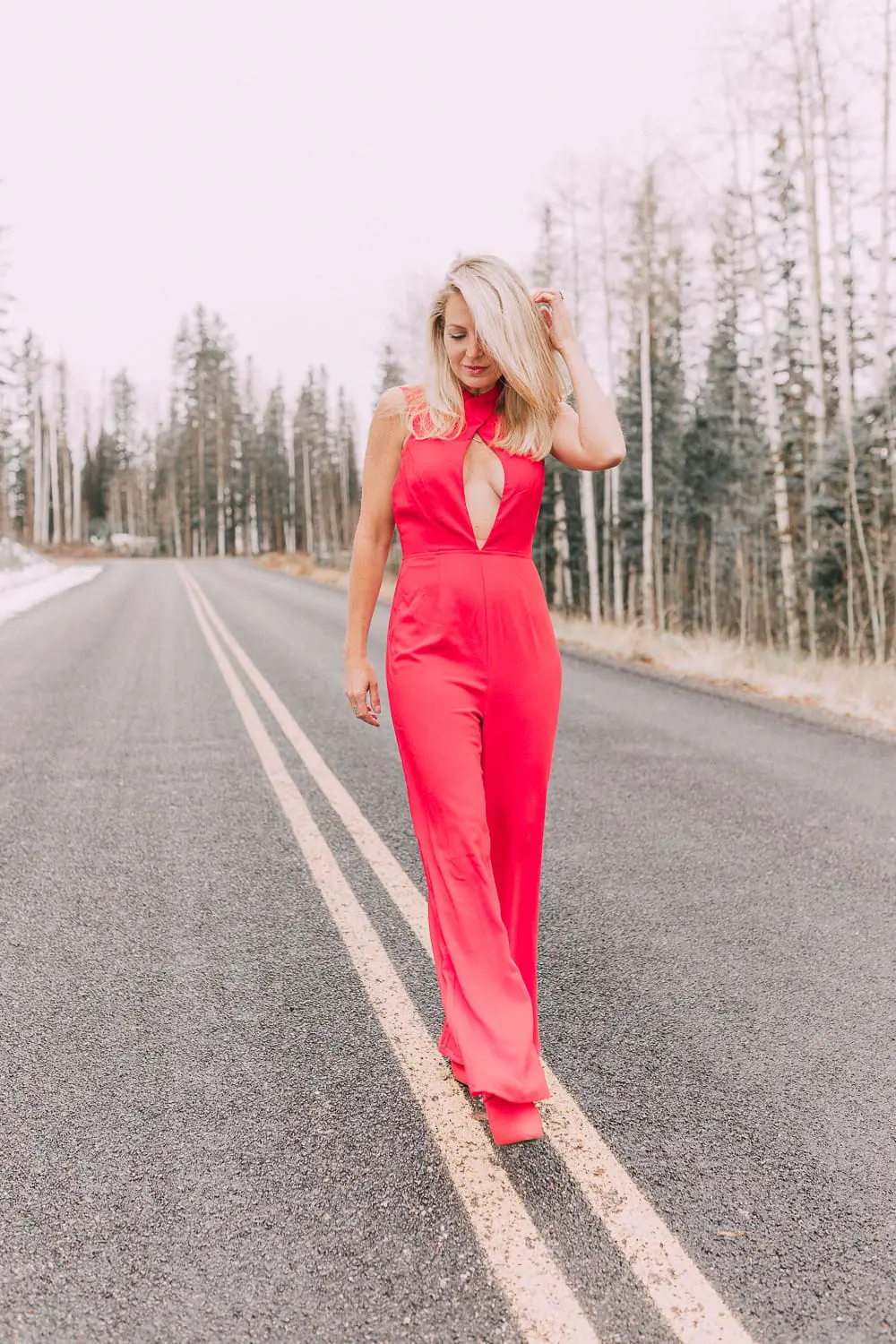 Fashion blogger Erin Busbee of BusbeeStyle.com wearing a red jumpsuit by by the way. from Revolve with red booties in Telluride, Colorado