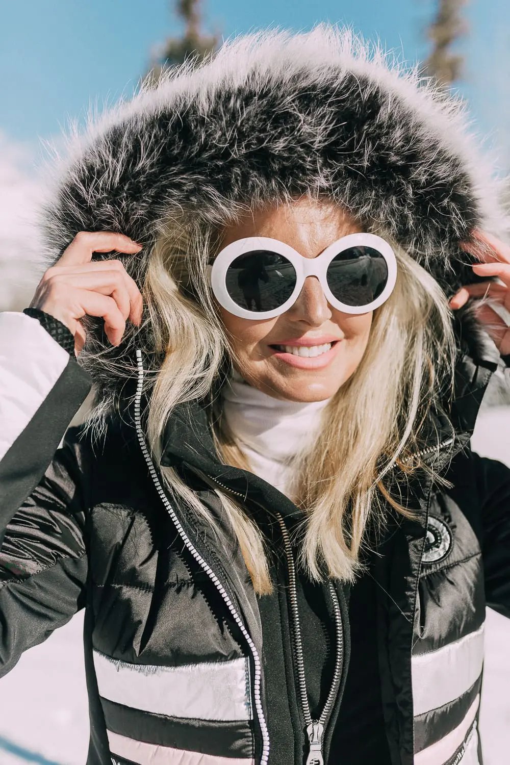 Ski Gear for women on eBay featuring a one-piece ski suit jumpsuit by Cordova on fashion blogger with blonde hair in snowy mountains, fashion blogger over 40 Erin Busbee of Busbeestyle.com