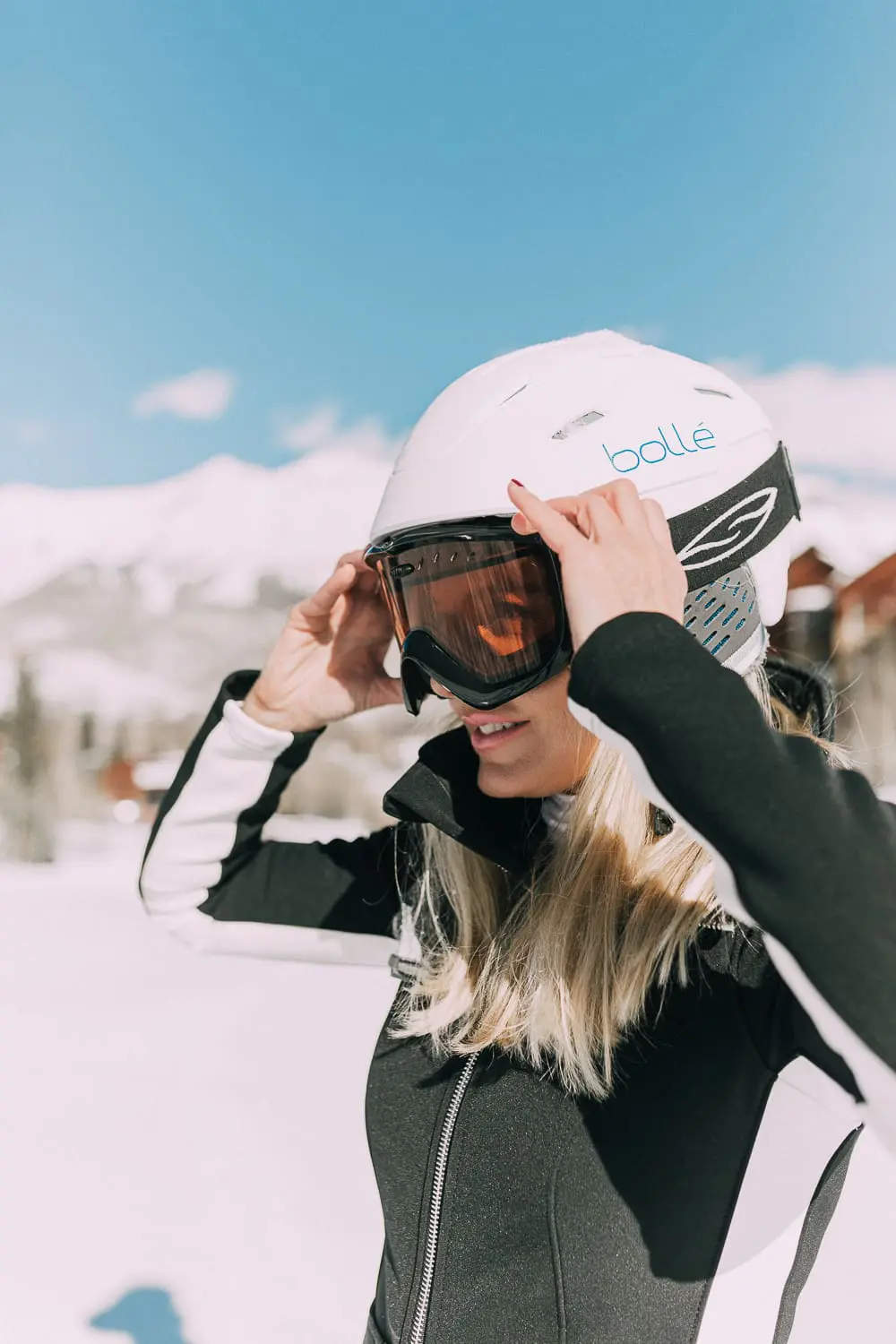 Ski Gear for women on eBay featuring a one-piece ski suit jumpsuit by Cordova on fashion blogger with blonde hair in snowy mountains, fashion blogger over 40 Erin Busbee of Busbeestyle.com